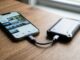 Person connecting Android phone to external hard drive using USB cable on a desk