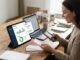 Small business owner using AI accounting software on a laptop in a modern office